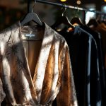 une-tenue-elegante-accrochee-sur-un-porte-vetements-presentant-des-tissus-raffines-dans-une-ambiance-chaleureuse-et-accueillante